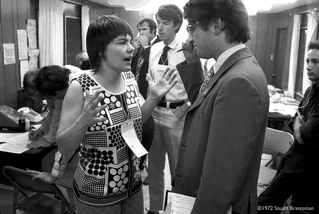 Judy Harrington talking with John McKean in the McGovern command trailer behind the stage of the 1972 Democratic National Convention.  Behind them is Ted Pulliam, and Alan Kriegel is on the right.
 – © 1972 Stuart Bratesman
